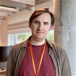 Smilende mann i kontorlandskap