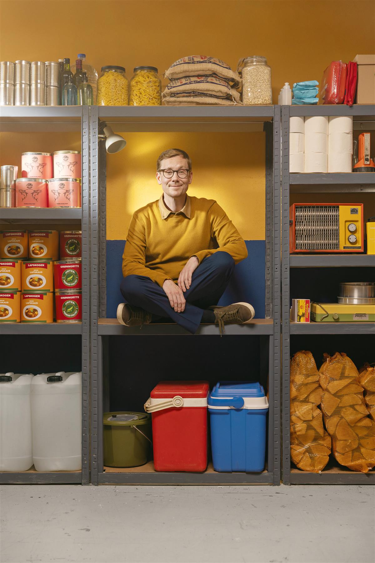 Mann sitter i lagerhylle - Klikk for stort bilde